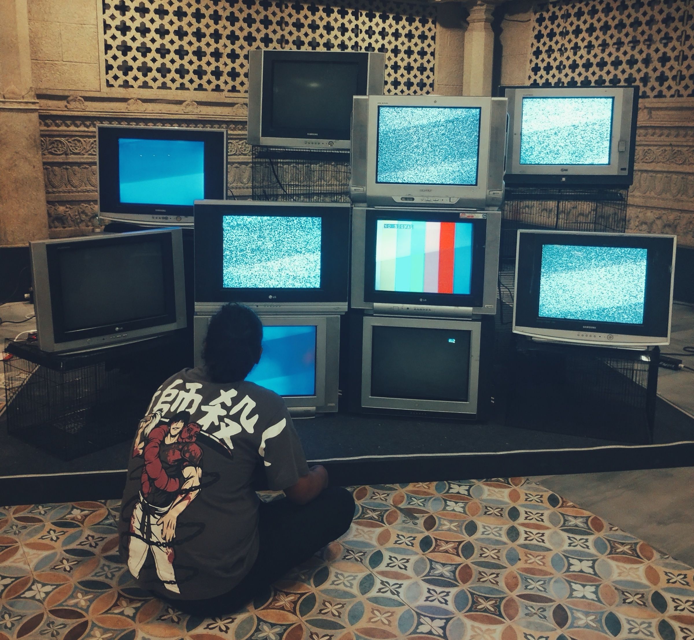 A person tests the assembled stack of CRT televisions before the festival.