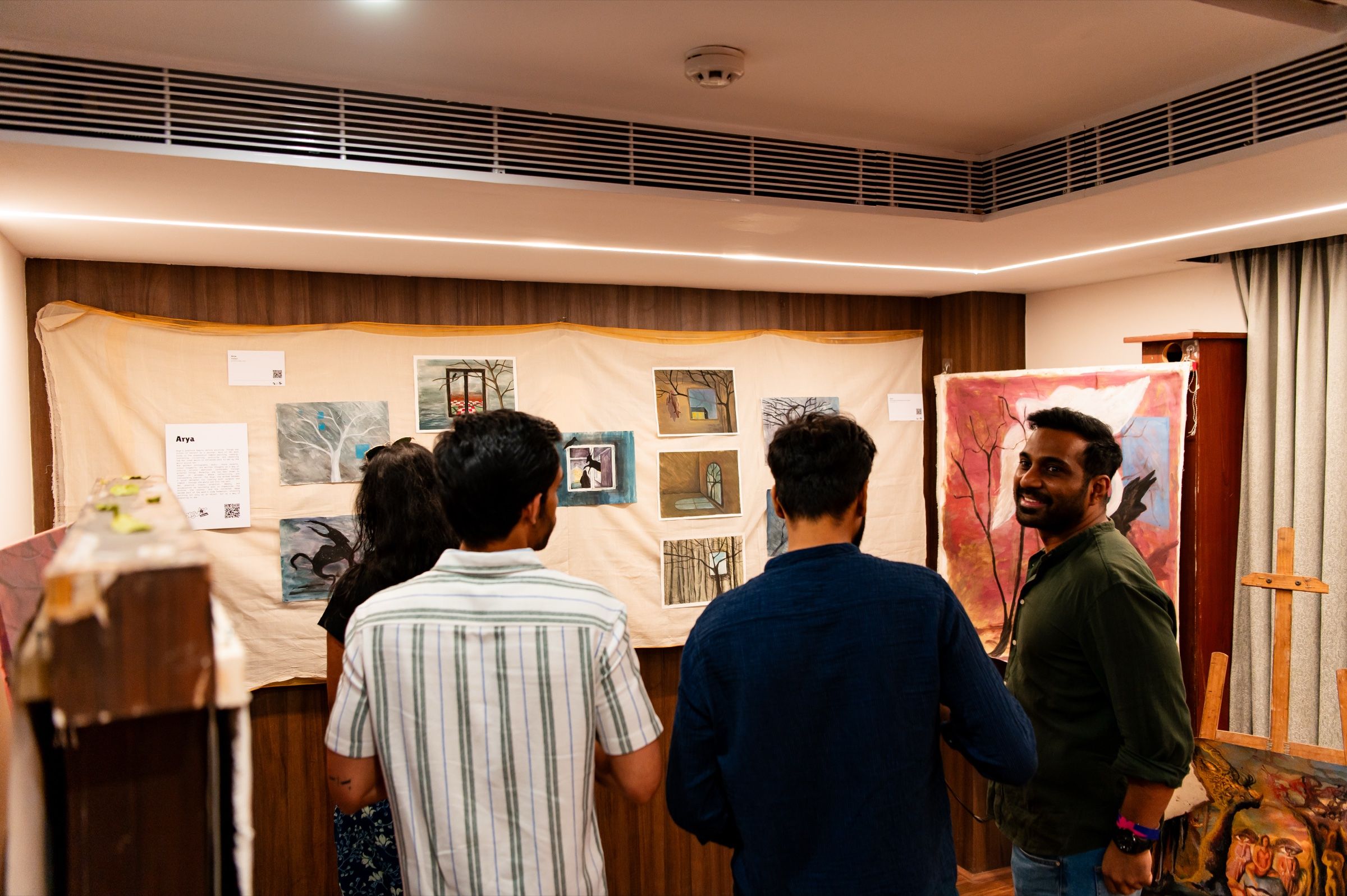 Visitors explore paintings, sculpture and a CRT video installation in The Angular Festival art gallery.