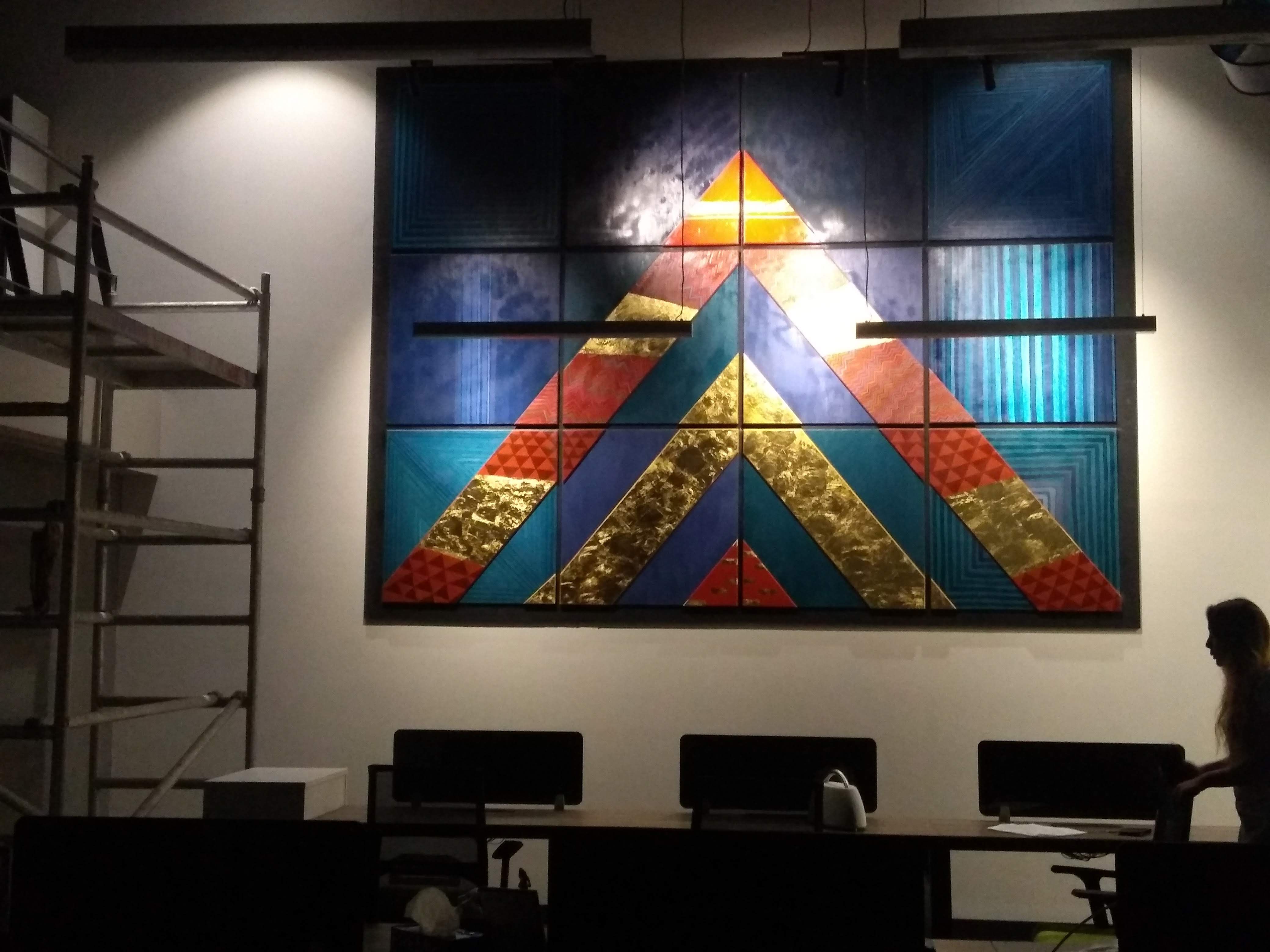 Large geometric blue, red and gold installation mounted in the Anand Rathi office.