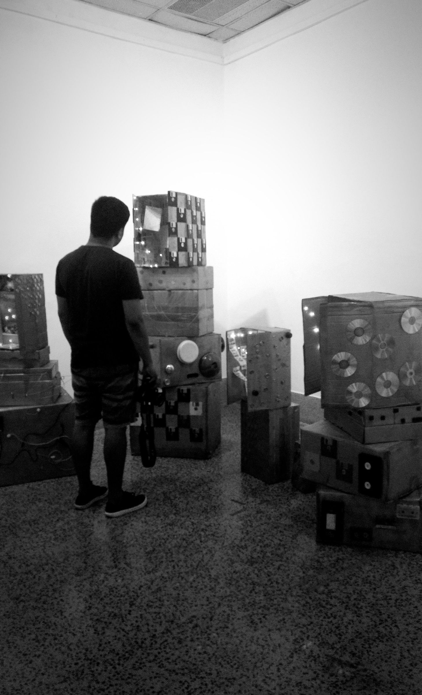 A visitor looks into the illuminated cardboard structures of Museum of Leftovers.